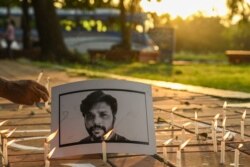 Journalists place candles next to a portrait of Reuters journalist Danish Siddiqui as a tribute in Kolkata on July 16, 2021.