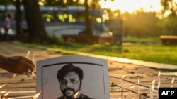 Journalists place candles next to a portrait of Reuters journalist Danish Siddiqui as a tribute in Kolkata on July 16, 2021.