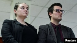 American couple Nicholas Spencer and his wife, Mackenzie Leigh Mathias Spencer, sit in the courtroom during the verdict where they are charged with torturing a 10-year-old at the High court in Kampala, Uganda, October 31, 2023. 