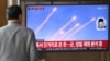 A man watches a television screen showing a news broadcast with file footage of a North Korean missile test, at a train station in Seoul on March 10, 2025.