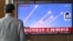A man watches a television screen showing a news broadcast with file footage of a North Korean missile test, at a train station in Seoul on March 10, 2025.