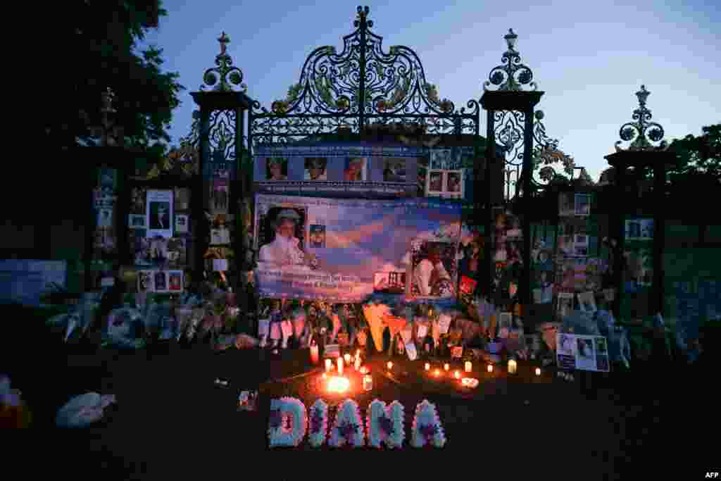 Floral tributes, candles and photographs are seen outside one of the entrances of Kensington Palace in London to mark the 20th anniversary of the death of Diana, Princess of Wales.