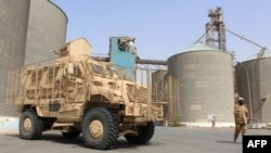 FILE - Soldiers with a military coalition in Yemen backed by Saudi Arabia and the United Arab Emirates stand guard at a facility of Yemen's Red Sea Mills company in the port city of Hodeida, Jan. 22, 2019.