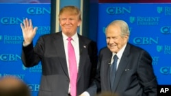 El 24 de febrero de 2016, el candidato presidencial republicano, Donald Trump, acompañado por el reverendo Pat Robertson, saluda cuando llega a la Universidad Regent en Virginia Beach, Virginia.