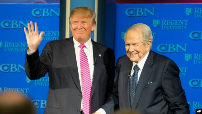 El 24 de febrero de 2016, el candidato presidencial republicano, Donald Trump, acompañado por el reverendo Pat Robertson, saluda cuando llega a la Universidad Regent en Virginia Beach, Virginia.