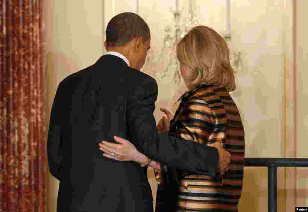 President Barack Obama and Secretary Clinton walk together off stage at a holiday reception for diplomats at the State Department in Washington, December 13, 2010. 