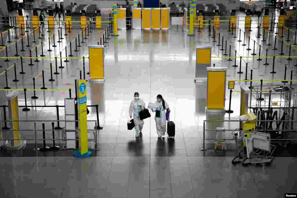 Passengers wearing special suits for protection against COVID-19 walk inside the Ninoy Aquino International Airport in Paranaque, Metro Manila, Philippines.