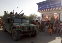 Taliban fighters stand guard at a checkpoint in Kunduz city, northern Afghanistan, Aug. 9, 2021.