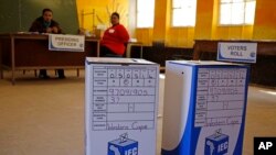Ballot boxes await voters as Election officials (background) await their arrival after they opened early for disabled people to vote in Nyanga township before Wednesdays official elections on the outskirts of the city of Cape Town, South Africa, May 5, 2