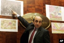 Shahin Gobadi from the secretariat of the National Council of Resistance of Iran shows photos and maps, on Sept. 20, 2005, during a press conference in Vienna.