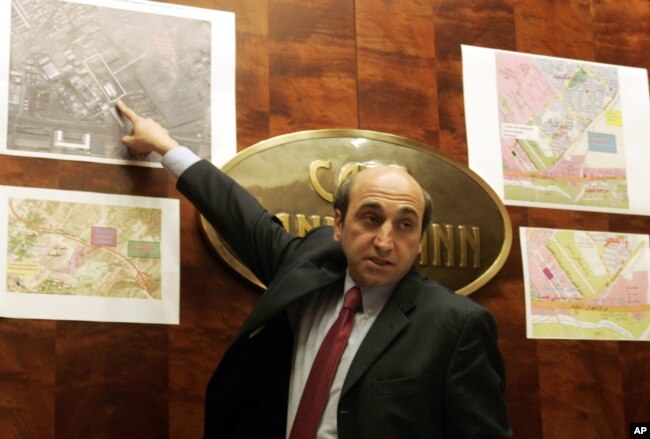 Shahin Gobadi from the secretariat of the National Council of Resistance of Iran shows photos and maps, on Sept. 20, 2005, during a press conference in Vienna.