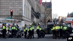 Boston police officers keep a perimeter secure in Boston's Copley Square as an investigation continues into the bomb blasts at the finish area of the Boston Marathon that killed 3 and injured more than 140 people, April 16, 2013.
