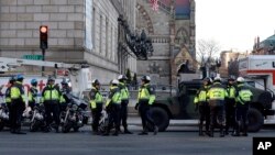 Polisi Boston terus berjaga di sekitar wilayah Copley, Boston saat berlangsungnya pemeriksaan lokasi ledakan bom (16/4). Kota-kota besar di AS telah meningkatkan keamanan di wilayahnya masing-masing menyusul tragedi bom Boston ini.