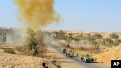 FILE - Iraqi army soldiers clear the roads of roadside bombs after defeating Islamic State extremists from villages outside Ramadi, west of Baghdad, Oct. 10, 2016.