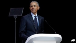 Former U.S. President Barack Obama, left, delivers his speech at the 16th Annual Nelson Mandela Lecture at the Wanderers Stadium in Johannesburg, South Africa, July 17, 2018.