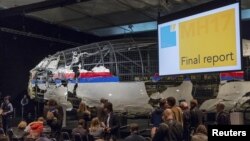 The reconstructed airplane serves as a backdrop during the presentation of the final report into the July 2014 crash of Malaysia Airlines flight MH17, in Gilze Rijen, the Netherlands, October 13, 2015.