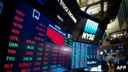 A TV screen shows the numbers after the closing bell at the New York Stock Exchange (NYSE) on August 14, 2019 in New York City. 