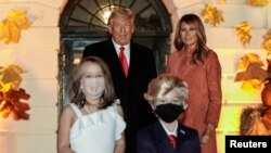Dua anak berdandan sebagai Presiden AS Donald Trump dan Ibu Negara Melania Trump menghadiri pesta Halloween yang diselenggarakan oleh Presiden Trump dan istrinya di Gedung Putih, di Washington, Minggu, 25 Oktober 2020. (Foto: Reuters)
