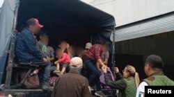 Miembros del Instituto Nacional de Migración (INM) y de las fuerzas de seguridad ayudan a casi 500 migrantes que fueron encontrados detenidas en una propiedad en Yehualtepec, en el central estado de Puebla. INM/via REUTERS