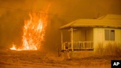 Las llamas se elevan cerca de una casa vacía cerca de Mariposa, California, el miércoles 19 de julio.