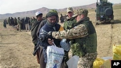 A Finnish soldier with the International Security Assistant Force gives donations to an Afghans in Chemtal district of Balkh province north of Kabul, Afghanistan on Wednesday, February 2008. (file photo)