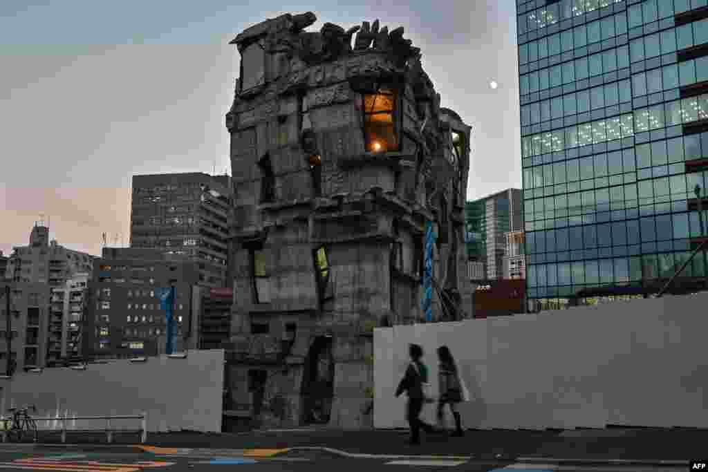 This photo taken on Nov. 13, 2024 shows pedestrians walking past the four-story Arimaston Building by Japanese architect Keisuke Oka in the Mita area of Minato Ward in Tokyo.&nbsp;Passers-by stop and stare at the ramshackle, hand-built concrete tower that looks like it has been lifted right out of a Japanese animation and dropped onto a real-life Tokyo street. Oka started construction in 2005.&nbsp;