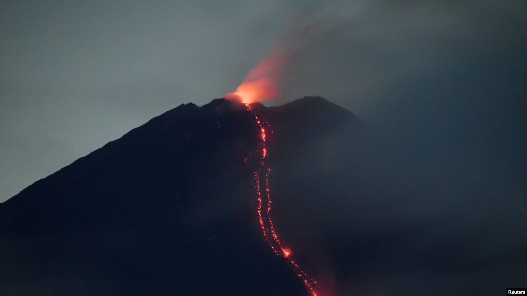 FILE - Mount Semeru volcano spews hot lava as it erupts, as seen from Oro-oro Ombo village in Lumajang, East Java province, Indonesia, January 17, 2021.