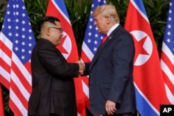 U.S. President Donald Trump shakes hands with North Korea leader Kim Jong Un at the Capella resort on Sentosa Island, June 12, 2018 in Singapore.