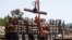 FILE - A worker unloads logs at the Murray Brothers Lumber Company in Madawaska, Ontario, Canada, July 4, 2018. 