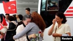 An employee (C) at Turkey's consulate in Mosul is welcomed by her relatives at Esenboga airport in Ankara, Turkey, Sept. 20, 2014. 