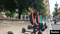 Electric scooters from Swedish startup VOI and Belin-based Tier sit parked side-by-side in Stockholm, Sweden, July 7, 2019. 