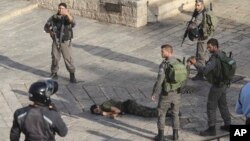 以色列警察站在一名企图刺杀耶路撒冷老城入口外的警卫时被击毙的袭击者身旁。 （2015年10月14日）