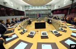 EU Chief Brexit Negotiator Michel Barnier, fifth right, and British Secretary of State David Davis, fourth left, participate in a round table meeting at EU headquarters in Brussels, June 19, 2017.