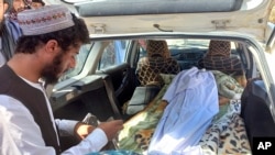 The covered body of a girl lies in the back of a vehicle after she was killed by an unexploded shell in Helmand province, southern Afghanistan, Sept. 3, 2022. 