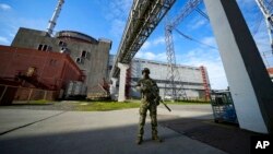 FILE - A Russian serviceman guards an area of the Zaporizhzhia nuclear power plant in territory under Russian military control, southeastern Ukraine, May 1, 2022.