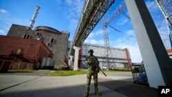 FILE - A Russian serviceman guards an area of the Zaporizhzhia nuclear power plant in territory under Russian military control, southeastern Ukraine, May 1, 2022.