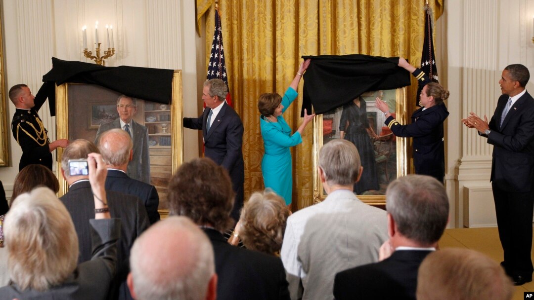 FILE - Then-President Barack Obama applauds at right as former President George W. Bush and former first lady Laura Bush unveil the Bush portraits during a ceremony in the East Room of the White House in Washington, May 31, 2012. 
