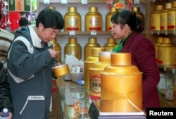 FILE - A man examines a sample of green tea at the Tianfu's Tea shop in Beijing in this undated photo. (REUTERS)