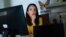 FILE - Juliana Macedo do Nascimento, 36, a Deferred Action for Childhood Arrivals program recipient who moved to the U.S. from Brazil when she was 14, participates in a Zoom call for her job with United We Dream, at her apartment in Washington, Sept. 2, 2022.
