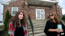 FILE - Former Bangor Christian Schools sophomore Olivia Carson, then 15, of Glenburn, Maine, left, stands with her mother Amy while getting dropped off on the first day of school on August 28, 2018 in Bangor, Maine. (Gabor Degre/The Bangor Daily News via AP, File)