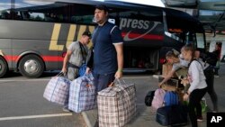 A family from Mariupol arrives from Russia in Narva, Estonia, June 16, 2022, more than a month after they left their hometown. Many Ukrainian refugees reportedly are forced to embark on a journey into Russia before being able to travel elsewhere.