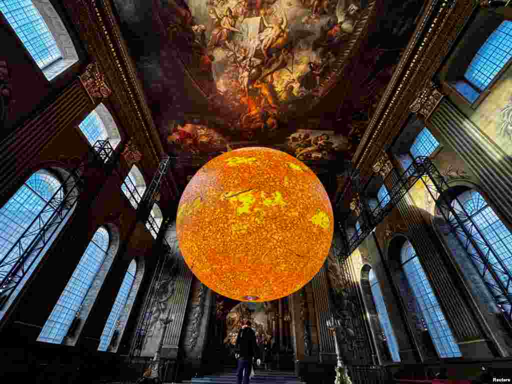 A large sun installation, &#39;Helios&#39; by Luke Jerram, is displayed in the Painted Hall at the Old Royal Naval College in London.