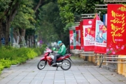 A delivery man waits for online order outside a cafe in Hanoi, Vietnam, April 1, 2020.