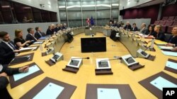 EU Chief Brexit Negotiator Michel Barnier, fifth right, and British Secretary of State David Davis, fourth left, participate in a round table meeting at EU headquarters in Brussels, June 19, 2017.