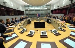 EU Chief Brexit Negotiator Michel Barnier, fifth right, and British Secretary of State David Davis, fourth left, participate in a round table meeting at EU headquarters in Brussels, June 19, 2017.
