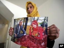 Somali refugee Nimo Hashi holds a photo of her husband Tuesday, Jan. 31, 2017, in Salt Lake City. Hashi bought a new kitchen table and couches for her Salt Lake City apartment in joyful anticipation of reuniting Friday with her husband for the first time in nearly three years. But he won't be arriving as planned to see her and the 2-year-old daughter he's never met. He is among hundreds of people stuck in limbo after President Donald Trump's executive order temporarily banned refugees and nearly all travelers from seven Muslim-majority countries, including Somalia.