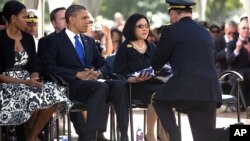 President Barack Obama and First Lady Michelle Obama look on from left as Irene Hirano Inouye, the widow of the late Sen. Daniel Inouye, is given the flag that was draped over her husband's casket during a memorial service at the National Memorial Cemete