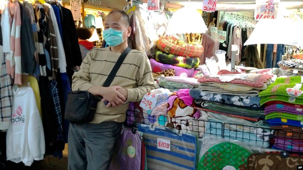资料照片:一名商贩戴着口罩在台北一家夜市戴着口罩等候顾客。(2020年2月6日)