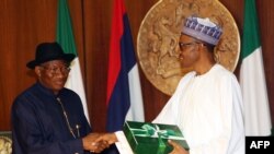 FILE- President-elect Mohammadu Buhari (R) shakes hands with Nigerian President Goodluck Jonathan (L) as he receives handover notes from him in Abuja on May 28, 2015.