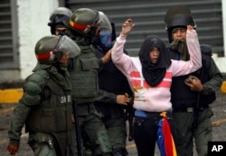 FILE - National Guard soldiers detain an anti-government demonstrator during clashes in Caracas, Venezuela, July 28, 2017.